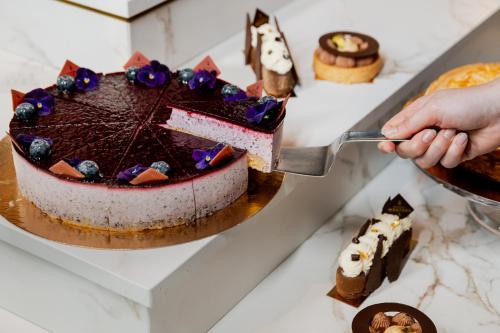 a person cutting a chocolate cake with a spatula at The Market Hotel in Groningen