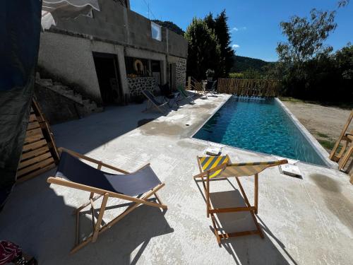 un groupe de chaises assises à côté d'une piscine dans l'établissement Domaine de Souchiol, à Coubon