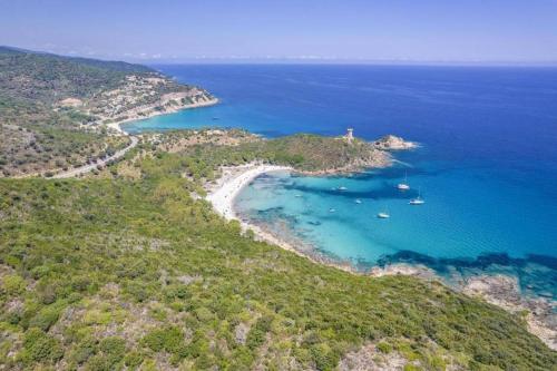 une vue aérienne d'une plage avec des bateaux dans l'eau dans l'établissement Villa Les Lofts de Sainte Lucie, à Sainte-Lucie de Porto-Vecchio