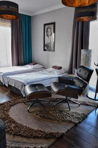 a bedroom with a bed and a pair of chairs at Villa Corleone in Kąty Wrocławskie