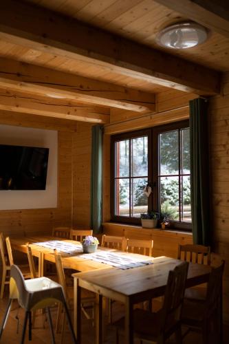 a dining room with tables and chairs and windows at Chalupa Albert in Červená Voda
