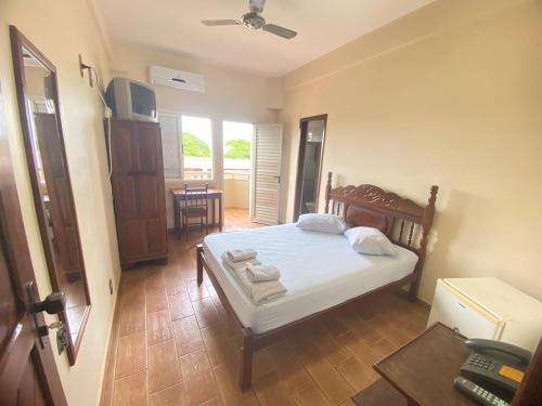 a bedroom with a bed with towels on it at Abaeté Palace Hotel in Abaeté