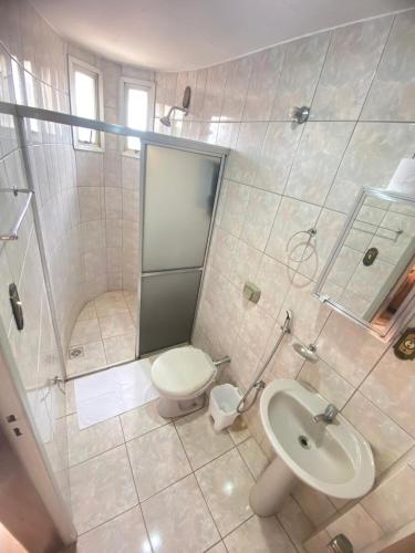 a bathroom with a shower and a toilet and a sink at Abaeté Palace Hotel in Abaeté