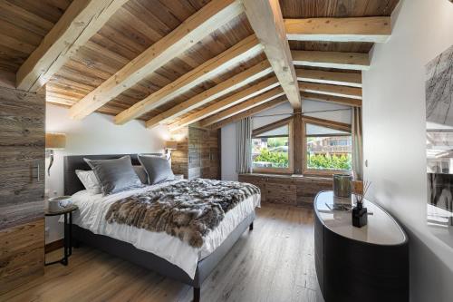 une chambre avec un grand lit et une grande fenêtre dans l'établissement Chalet Le Chardon Bleu, à Megève
