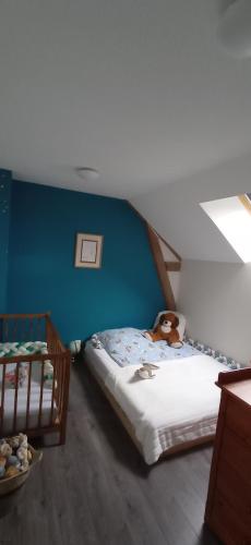 a bedroom with a bed with a teddy bear on it at Gîte Le Bel Air in Reigny