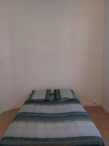 Ce lit se trouve dans un dortoir blanc doté d'un matelas. dans l'établissement T2 Centre ville Béziers, à Béziers