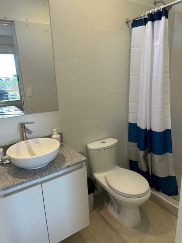 a white bathroom with a toilet and a sink at Casa Paraquitas "Casa Frente al mar de Paracas" in Paracas