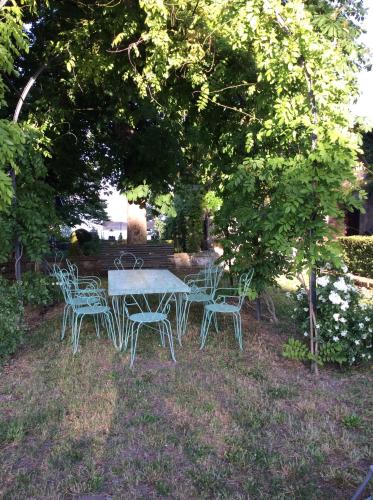 a table and chairs sitting under a tree at Il Giardino e la Dimora in Bomarzo