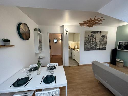 un salon avec une table blanche et un canapé dans l'établissement Appart T3 confort 4-6 pers - CLIM-Hypercentre, à La Flèche