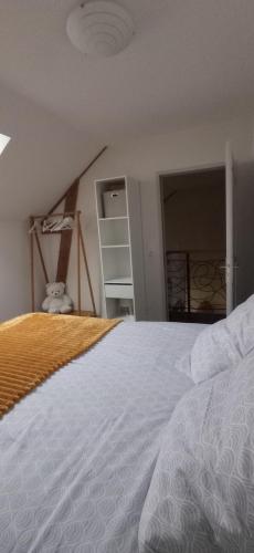 a bedroom with a white bed and a closet at Gîte Le Bel Air in Reigny