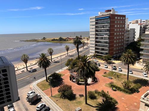 a view of a street with palm trees and a building at Rambla Apart in Montevideo