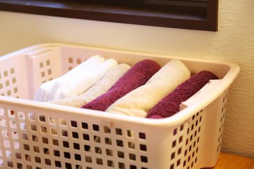 a laundry basket filled with purple and white towels at 那須コテージ アン in Nasushiobara