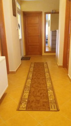 a rug on the floor in a hallway with a door at Orgona Vendégház in Murakeresztúr