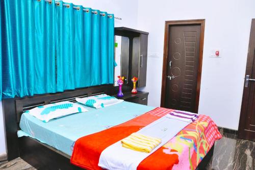 a bedroom with a bed with a blue curtain at Dream Hampi Villa & Home Stay in Hampi