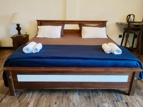 a bedroom with a bed with blue sheets and white pillows at The Quale Villa in Galle