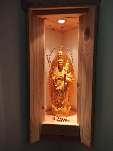 a gold buddha statue in a display case at Orgona Vendégház in Murakeresztúr