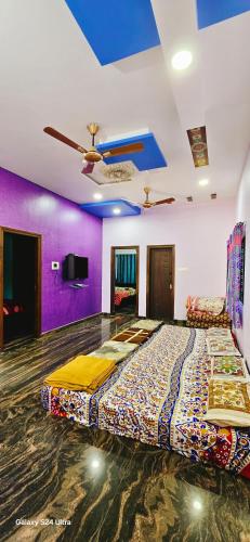 a large bed in a room with purple walls at Dream Hampi Villa & Home Stay in Hampi