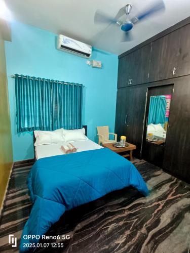 a bedroom with a bed and a blue wall at Dream Hampi Villa & Home Stay in Hampi