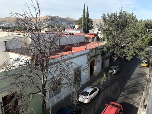 a white car parked on a street next to buildings at Casa Luna in Oaxaca City