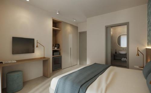 a bedroom with a bed with a television and a bathroom at Victoria Frontemare Beach & Spa Hotel Jesolo in Lido di Jesolo