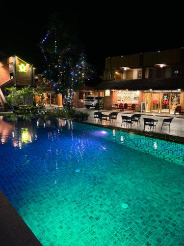 a large blue swimming pool at night with lights at U OLIVE Hotel in Ban Nua
