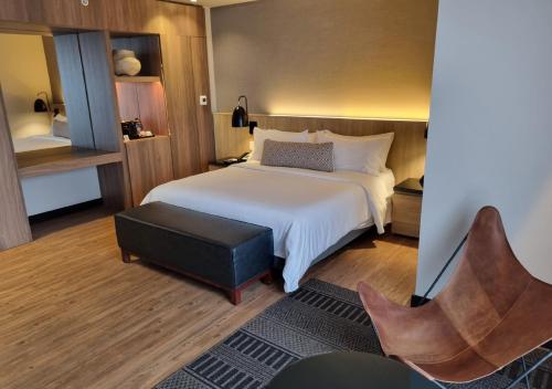 a hotel room with a bed and a chair at Movich Hotel de Pereira in Pereira