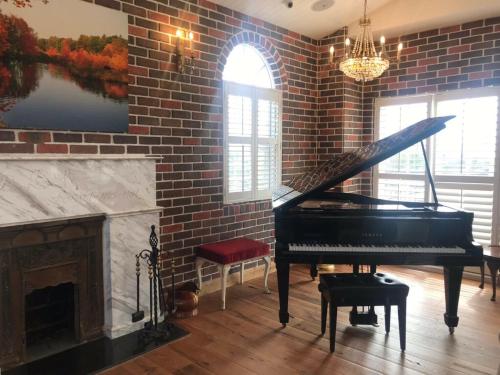 a living room with a piano and a brick wall at 墾丁勿忘我城堡莊園 in Hengchun