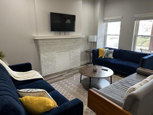 a living room with blue couches and a fireplace at Lovely 2BR Near Downtown Area in Columbus
