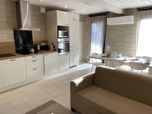 a living room with a couch and a kitchen at Grand Chalet de Pitrot in Lacanau