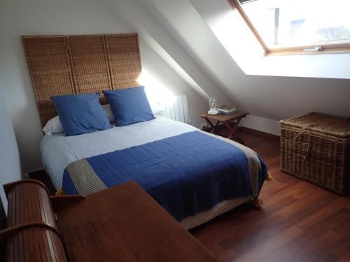 une chambre avec un lit avec des draps bleus et une fenêtre dans l'établissement Duplex vue sur mer, à Penthièvre