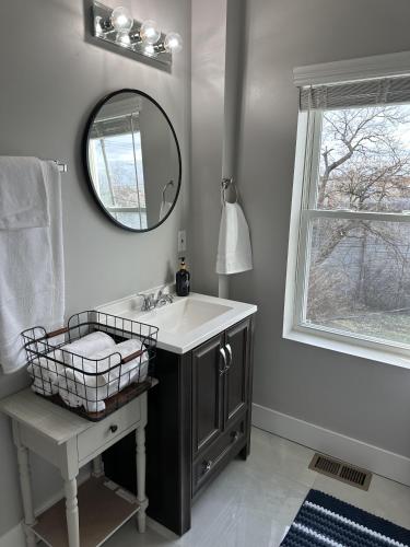 a bathroom with a sink and a mirror and a window at Lovely 2BR Near Downtown Area in Columbus