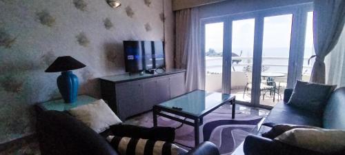 a living room with a couch and a table with a television at Regency Tanjung Tuan - Idealhub in Port Dickson