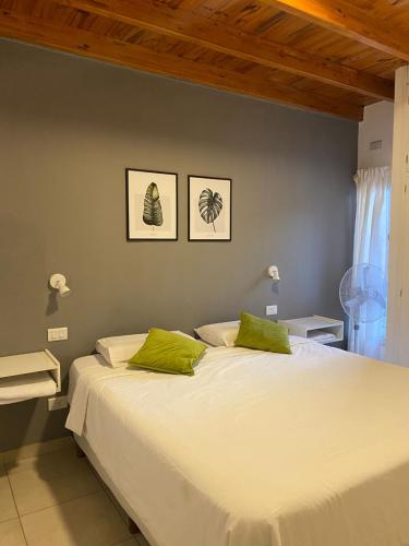 ein Schlafzimmer mit einem großen weißen Bett mit grünen Kissen in der Unterkunft Departamento para 4 personas con cochera in Godoy Cruz