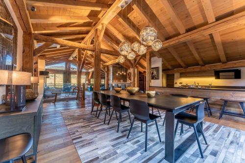 une salle à manger avec un plafond en bois, une table et des chaises dans l'établissement Chalet les Oyats - SKI IN SKI OUT, à Megève