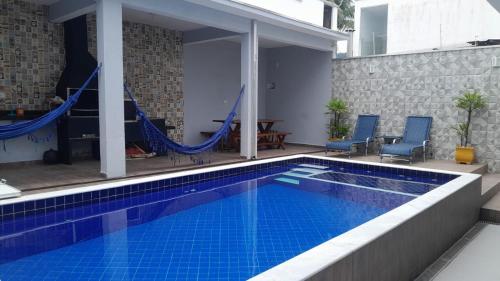 een zwembad met een hangmat in een huis bij Martin de Sá-200 metros da praia in Caraguatatuba