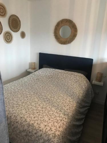 une chambre avec un lit et un miroir au mur dans l'établissement Studio spacieux bord de mer, à Camiers