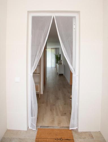 a white door with curtains in a hallway at Jamaica Beach House in Puebla de Farnals