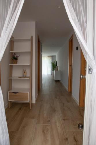 a hallway with wooden floors and a white curtain at Jamaica Beach House in Puebla de Farnals