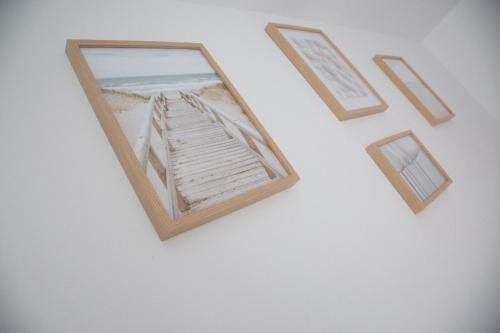 a picture of a beach in a frame on a wall at Jamaica Beach House in Puebla de Farnals