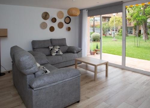 a living room with a couch and a table at Jamaica Beach House in Puebla de Farnals