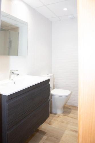 a bathroom with a sink and a toilet at Jamaica Beach House in Puebla de Farnals