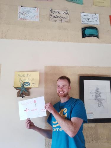 a man is holding up a piece of paper at Hostal Casa Grande in Villazón