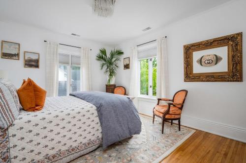 a bedroom with a bed and a chair and windows at 3bed 2bath heritage duplex - Prime Location in Collingwood