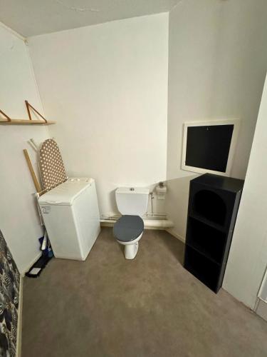 une petite salle de bains avec toilettes et une télévision. dans l'établissement Majestic - Wifi - Parking - Vue, à Dax