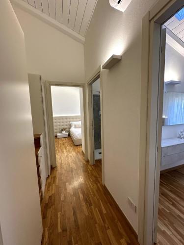 a room with a hallway with a bed and a window at Grenier Blanc2 Elegante Mansarda in San Vicenzo di Galliera