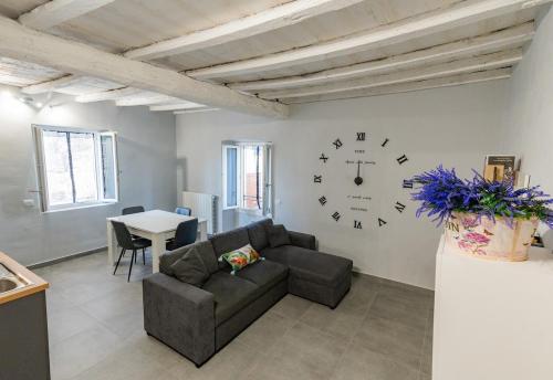 a living room with a couch and a clock on the wall at La Perla sul Lago in Pescate