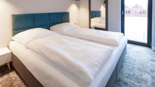 two beds with white sheets in a bedroom at VacationClub - Baltin Apartament 21 in Mielenko