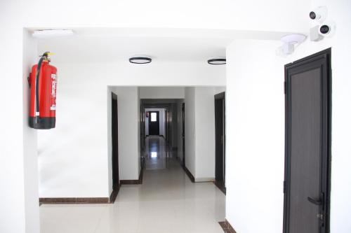 a hallway with a fire extinguisher on the wall at HOTEL NAKHIL in Nouadhibou
