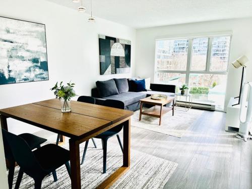 a living room with a table and a couch at Beautiful condo beach side Yaletown in Vancouver