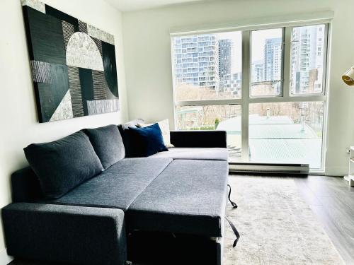 a living room with a couch and a large window at Beautiful condo beach side Yaletown in Vancouver